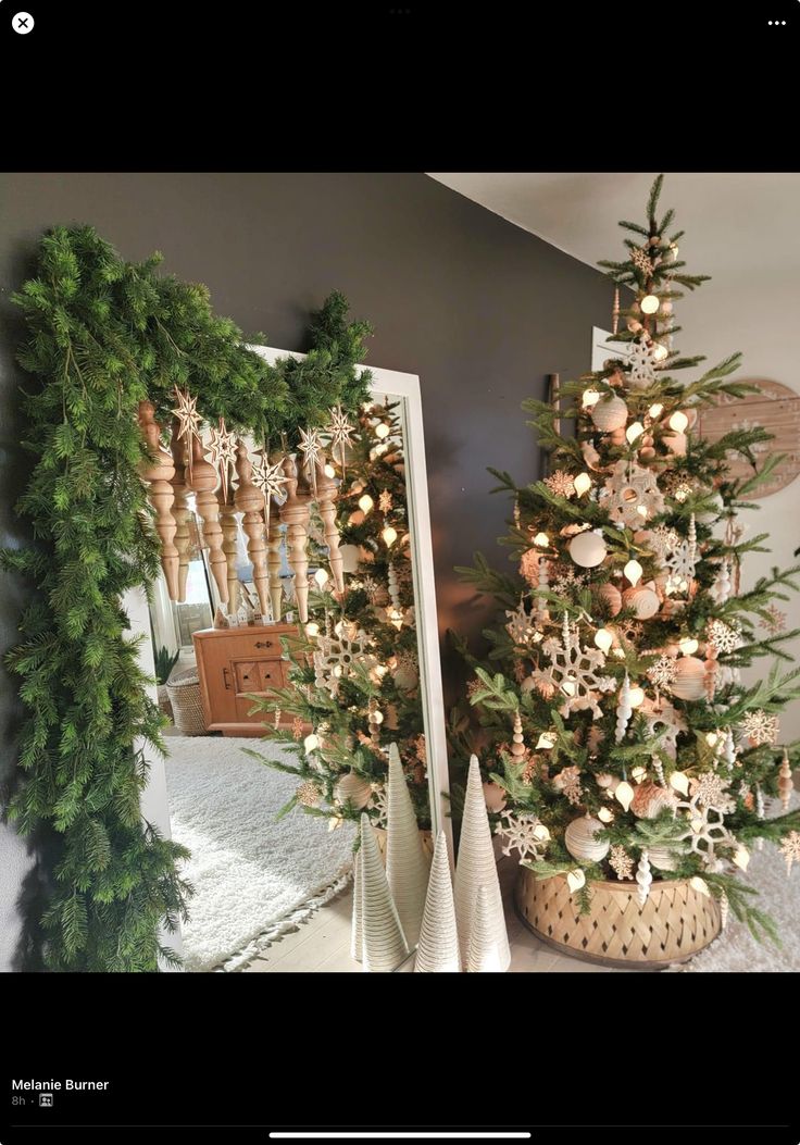 two small christmas trees in front of a mirror