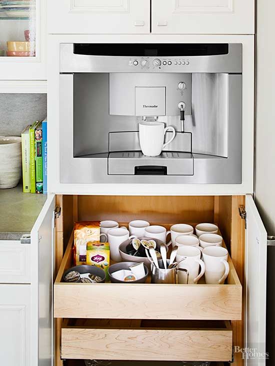 a coffee maker is in the middle of a cabinet with cups and mugs on it