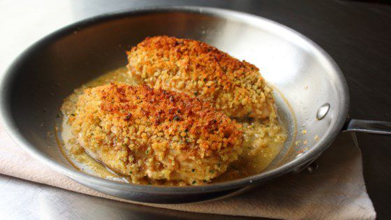 two fried meat patties in a pan on top of a table with a napkin