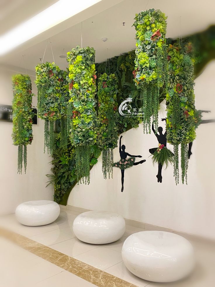 a room with plants growing on the wall and hanging from it's ceiling, as well as two people doing acrobatics