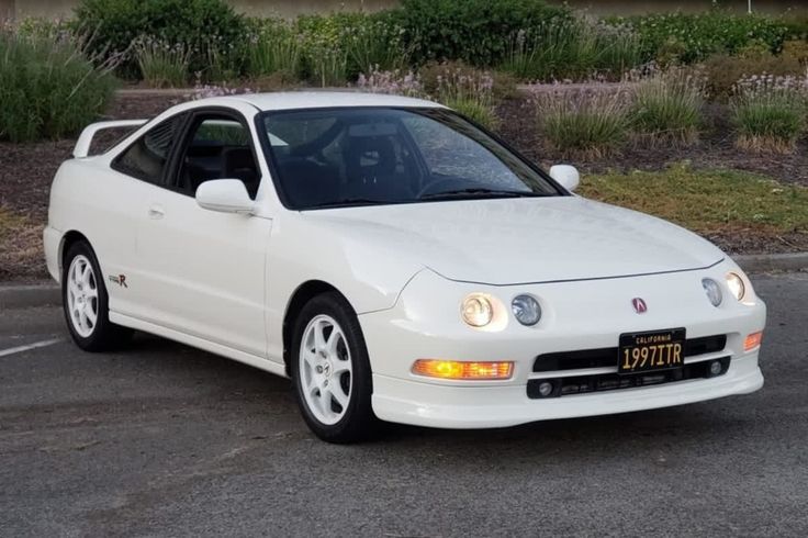 a white sports car parked in a parking lot