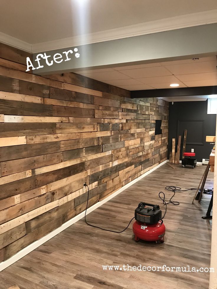 a room that has wood planks on the wall and a red vacuum in front of it