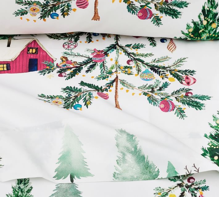 two sheets with christmas trees on them and a red barn in the background, both covered by white sheeting