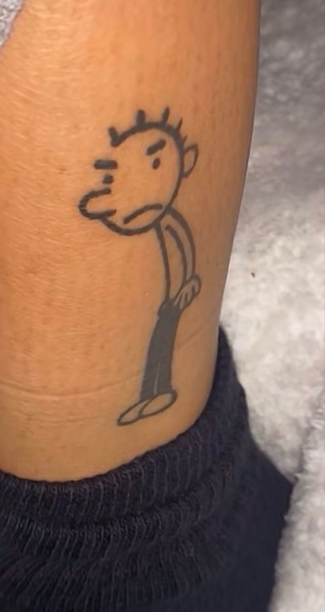 a person with a tattoo on their leg that has a cartoon character drawn on it