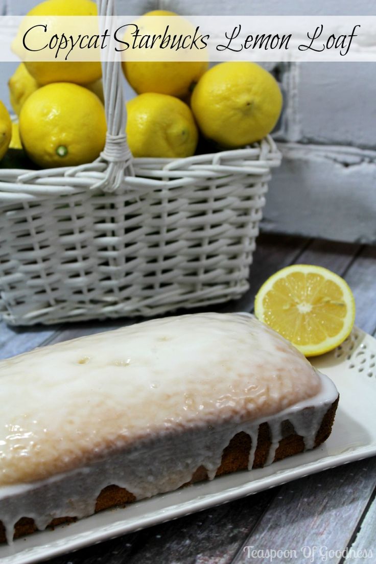 a lemon loaf sitting on top of a white plate next to a basket of lemons