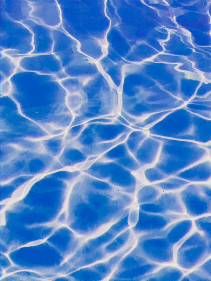 the water is very clear and blue with ripples on it's surface,