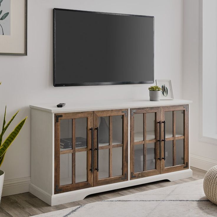 a flat screen tv mounted to the side of a white wall in a living room