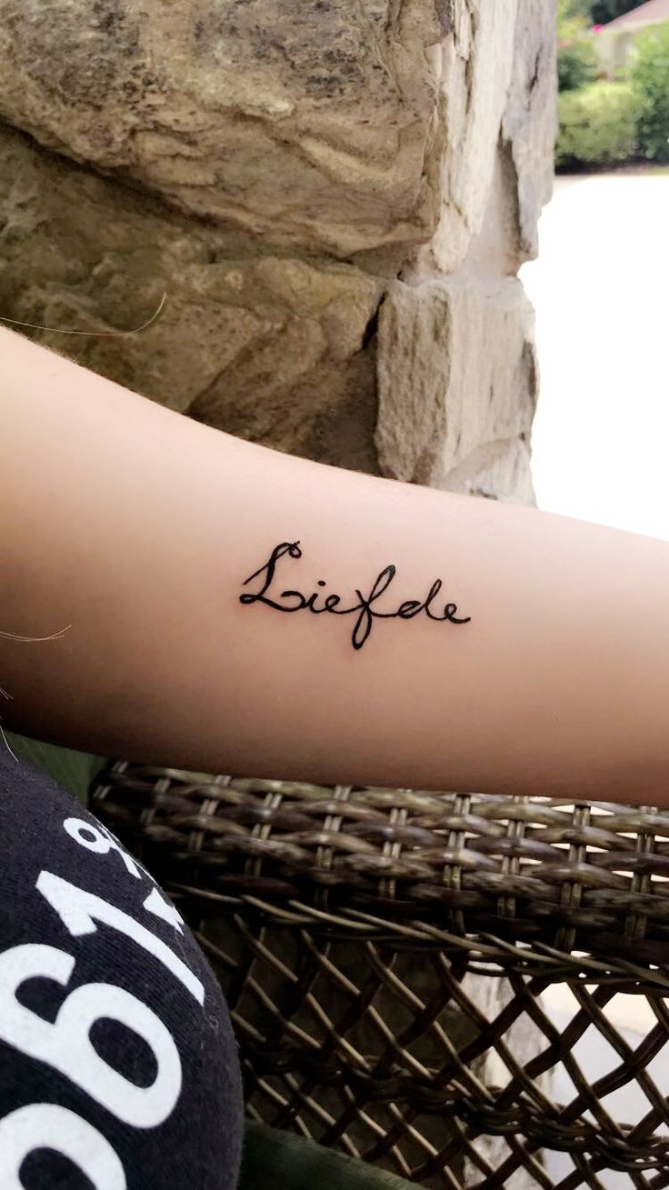 a person with a tattoo on their arm and the word elifle written in cursive writing