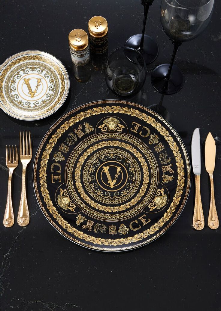 a black and gold table setting with silverware