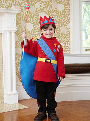 a young boy dressed in a red uniform holding a blue flag and smiling at the camera