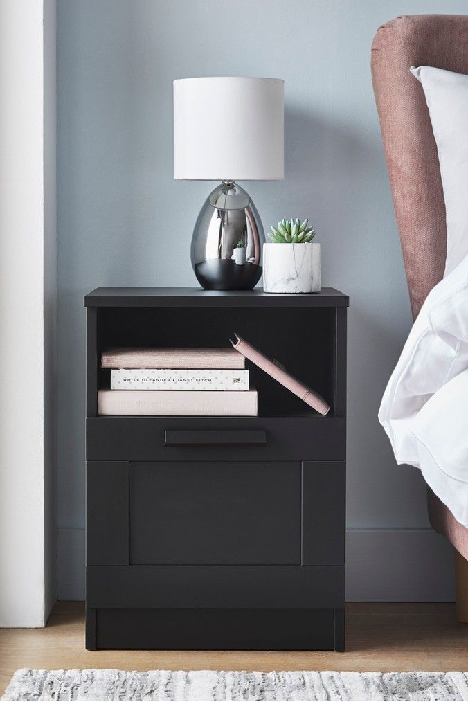 a nightstand with books and a lamp on it