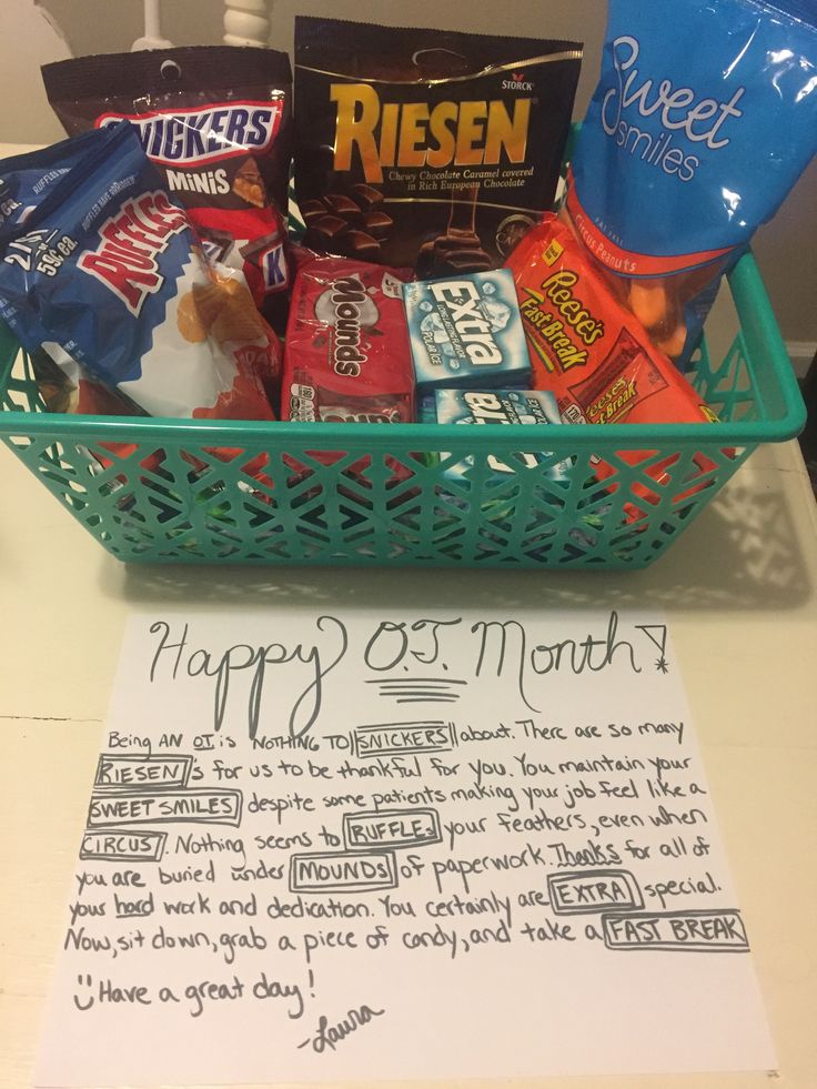 a basket filled with candy and snacks sitting on top of a table next to a note