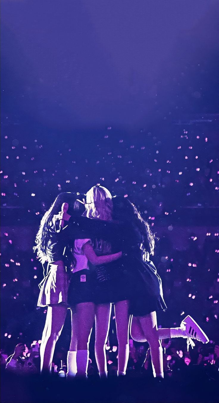 two girls hugging each other on stage with confetti in the air behind them