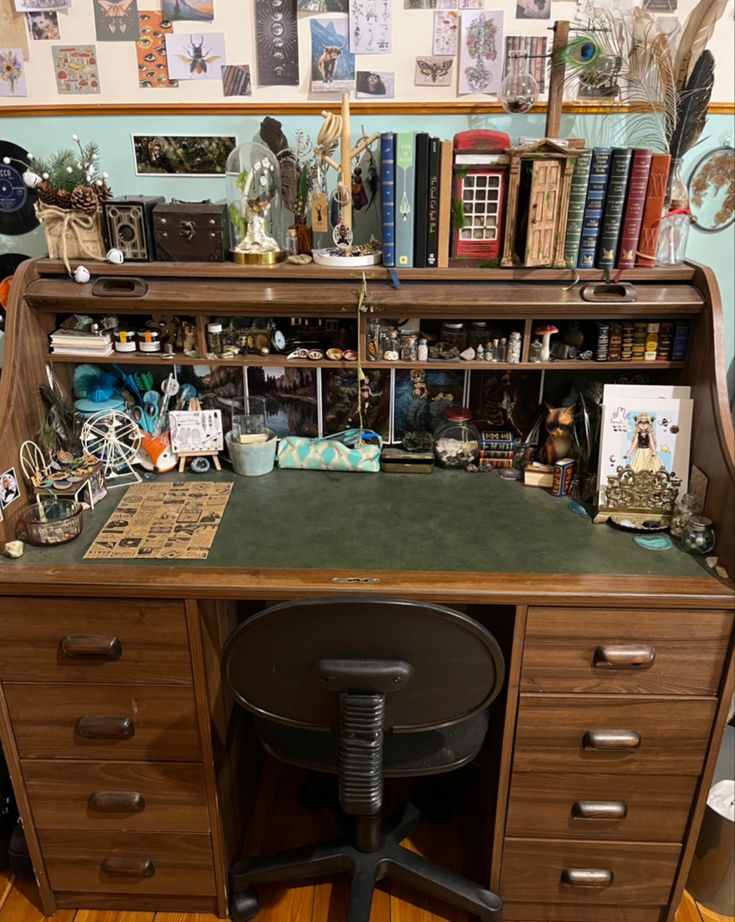 a desk with many books and pictures on the wall