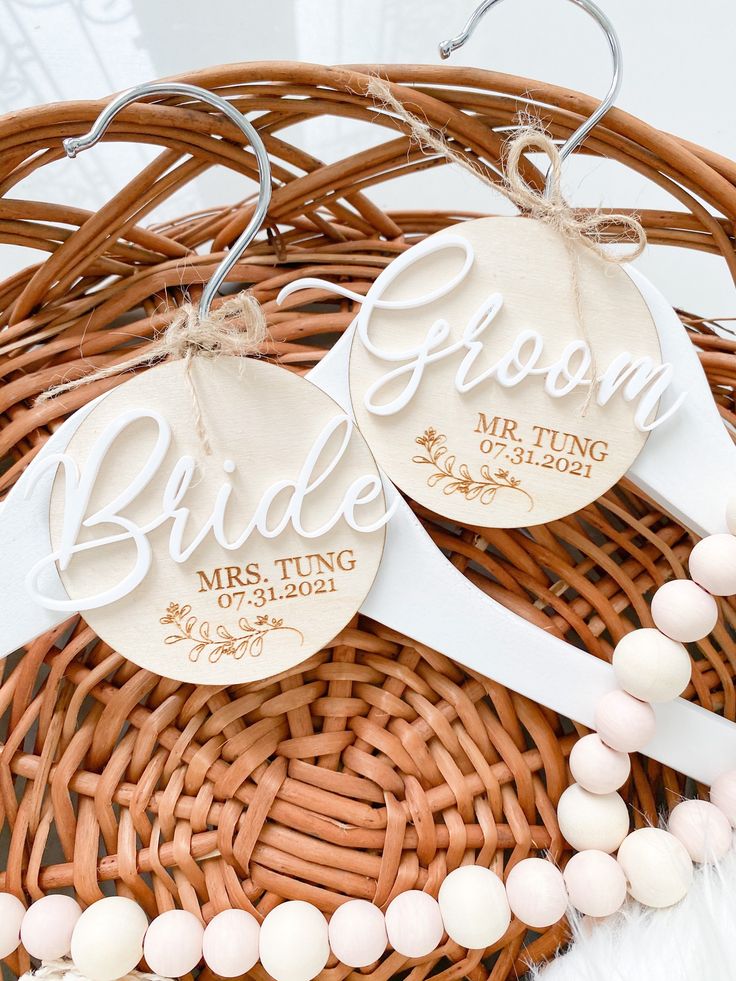 two bride and groom wedding tags in a wicker basket with white beaded necklaces