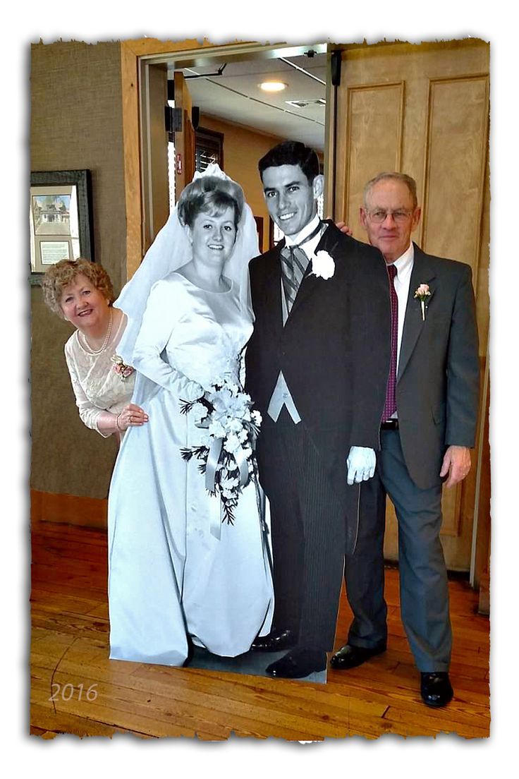 a man in a suit and tie standing next to a woman wearing a wedding dress