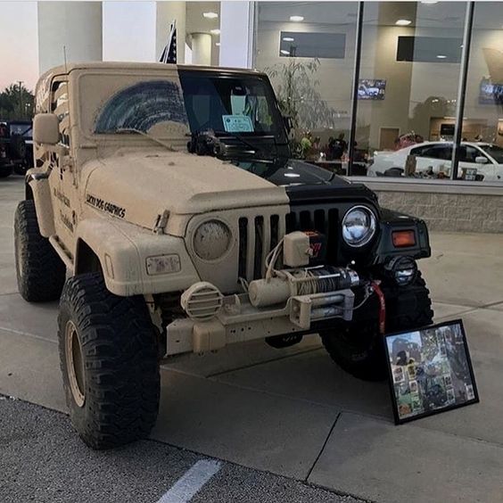 an army jeep parked in front of a building with pictures on the ground next to it