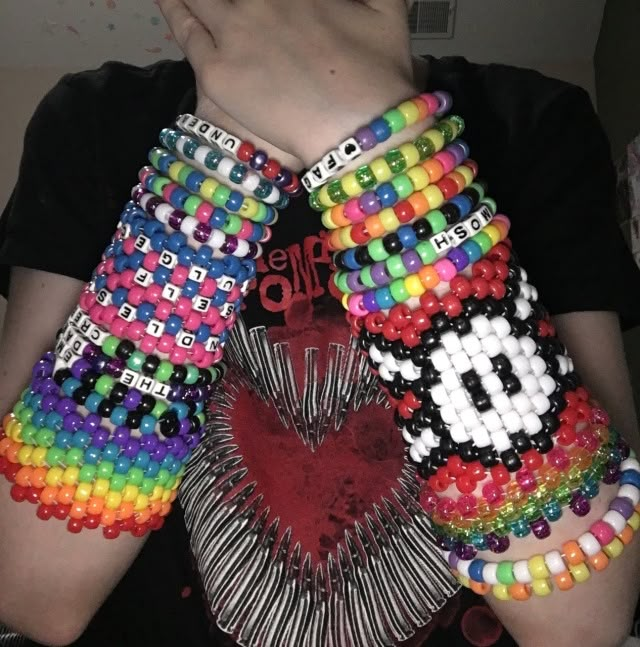 a woman holding several colorful bracelets in her hands with the letter d on them