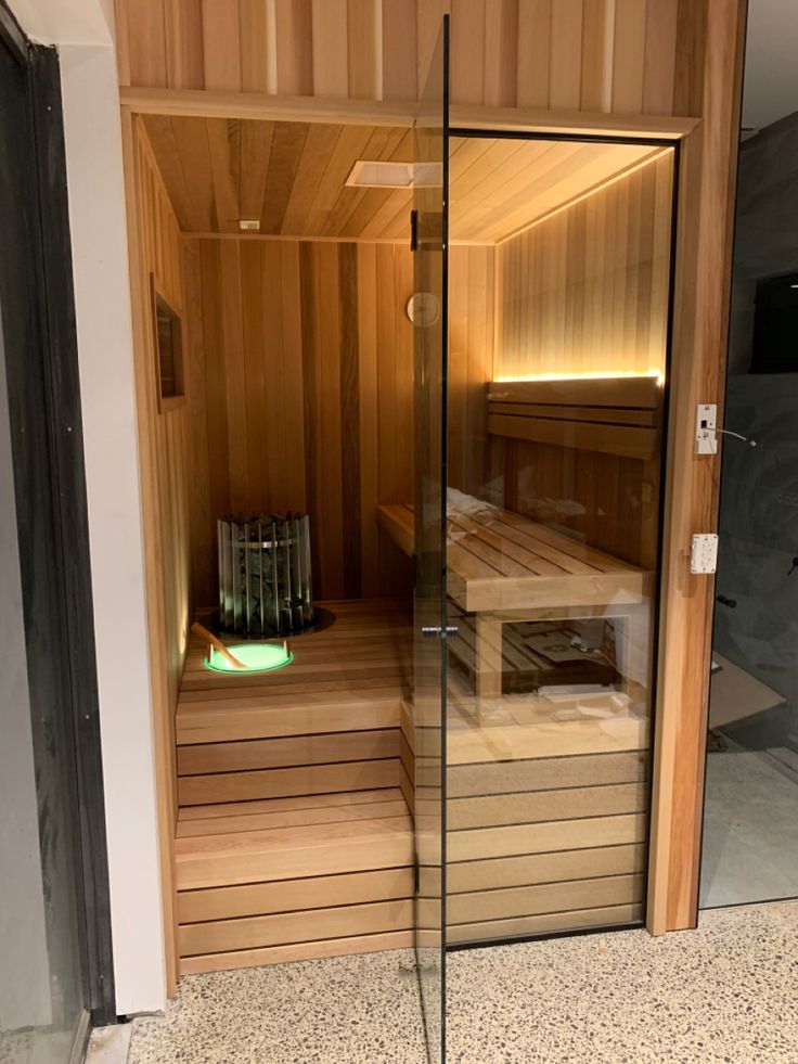 the inside of a sauna is shown with glass doors and wooden steps leading up to it