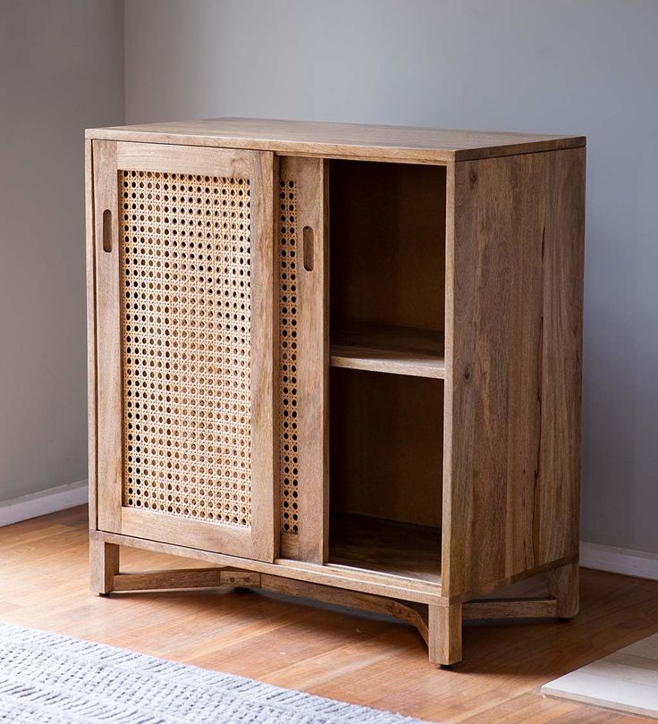 a wooden cabinet sitting on top of a hard wood floor next to a white rug