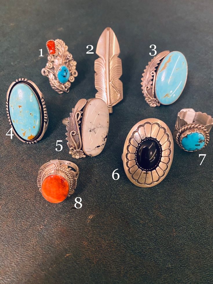 Our Outlaw Ring Collection features genuine stones, and sterling silver. Each ring is handcrafted by Navajo artisans. They are all one-of-a-kind. Pick the number of your favorite and check the description for sizing information. 1: Size 8: Turquoise and coral ring with ornate silver work. Stamped Sterling, HBY. 2: Size 6.5: Sterling feather ring measures 2" long. Stamped sterling, C.C. 3: Size 7.25: Massive 1.25 x .75" turquoise stone with ornate feather and flower details. Stamped Peterson John Cowgirl Accessories, Cowgirl Jewelry, Turquoise Jewelry Native American, Feather Ring, Vintage Style Jewellery, Ring Collection, Turquoise Cuff, Silver Work, Western Jewelry