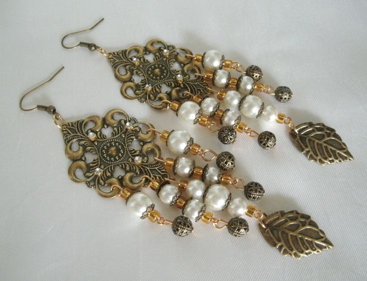 "Medieval Earrings These beautiful earrings have gold plated filigree settings, pearl beads, seed beads, rhinestones, antique gold leaf charms, gold plated filigree beads and gold plated bead caps. 4\" long from hook bottom." Metal Pendant Earrings For Wedding, Elegant Formal Beaded Dangle Earrings, Gold Victorian Baroque Earrings, Gold Baroque Victorian Earrings, Ornate White Dangle Earrings, Elegant Antique Gold Jewelry For Party, Elegant Gold Baroque Jewelry, Elegant Antique Gold Party Jewelry, Victorian Dangle Chandelier Earrings For Parties