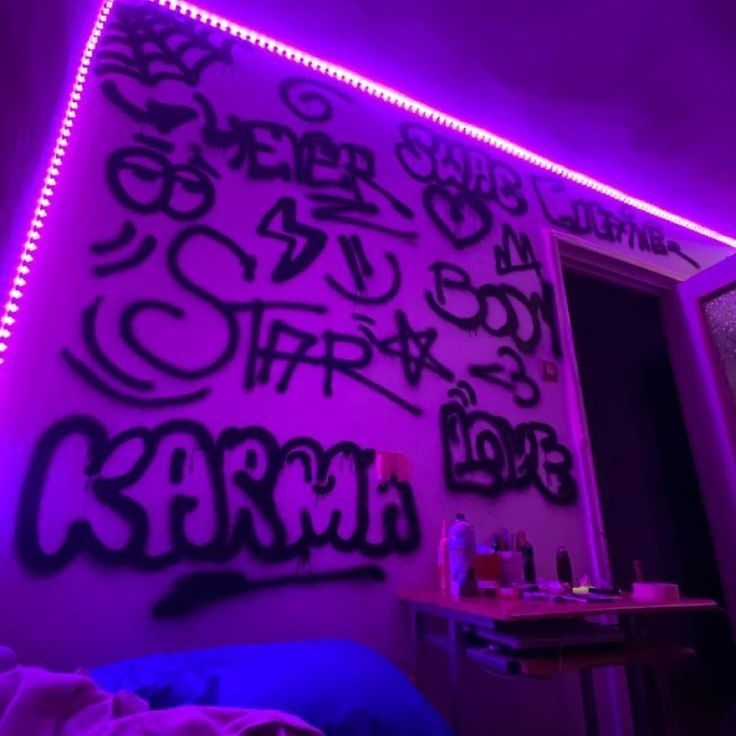 a bedroom with purple lights and graffiti on the wall