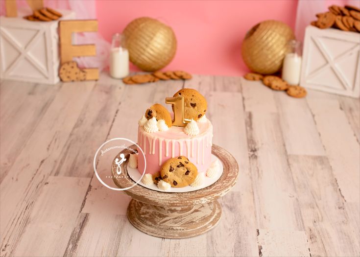 there is a cake with cookies on top and pink icing in the shape of letters