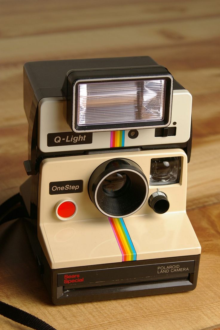 an old polaroid camera sitting on top of a wooden table