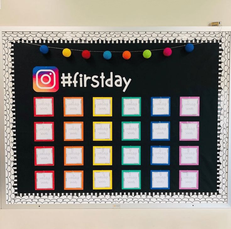 a bulletin board with the words first day written on it and colorful balls hanging from strings