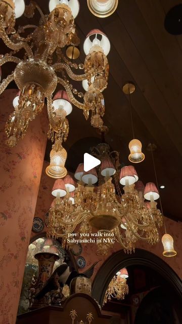 a chandelier hanging from the ceiling in a room with many lights on it