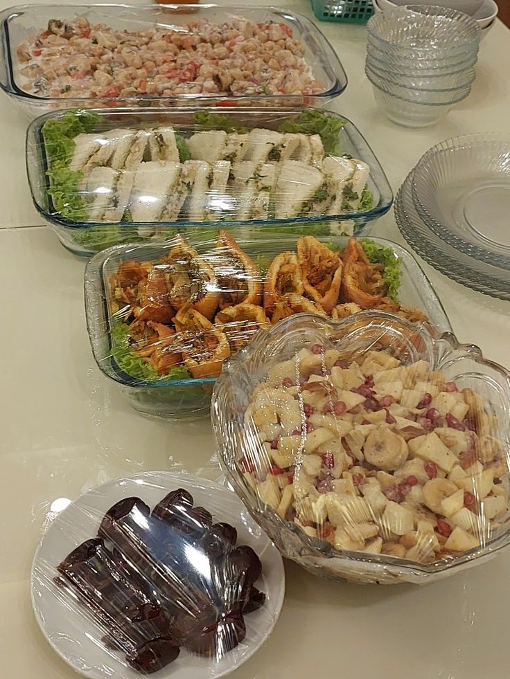 a table filled with lots of food on top of glass dishes and plates next to each other