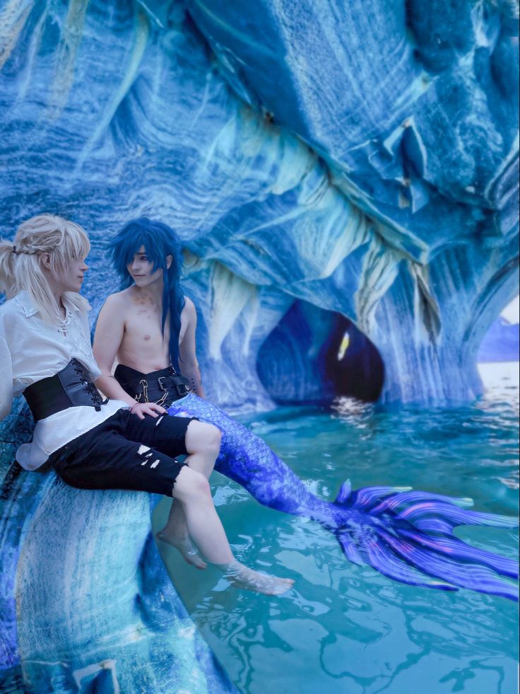 two people sitting on the back of a fake mermaid in an ice - like environment