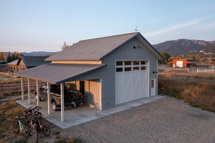 a garage with two bikes parked in front of it and mountains in the back ground