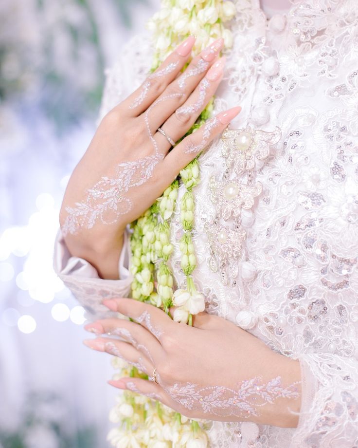 a close up of a person wearing white gloves and holding flowers in her hand with both hands