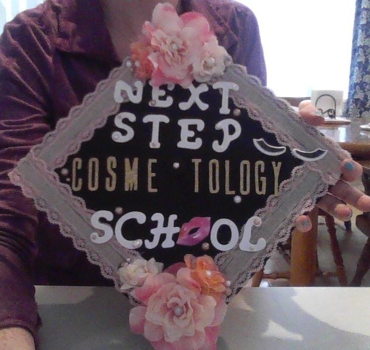 a woman holding up a sign that says next step cosme technology school