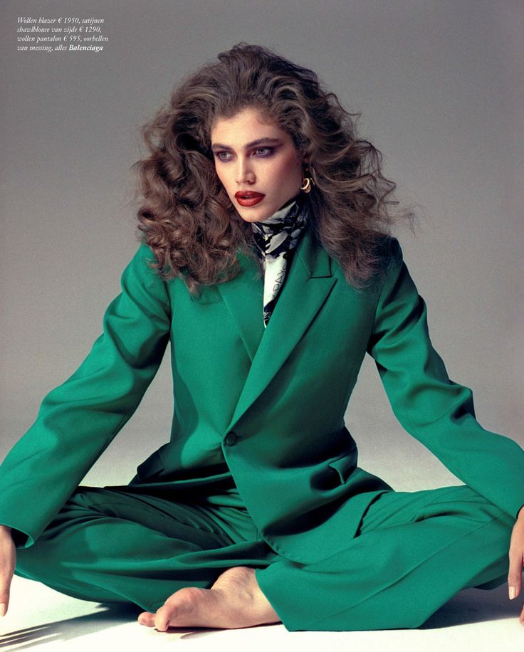 a woman in a green suit sitting on the ground