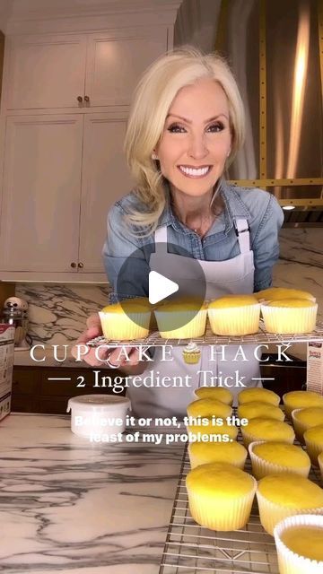 a woman standing in front of some cupcakes