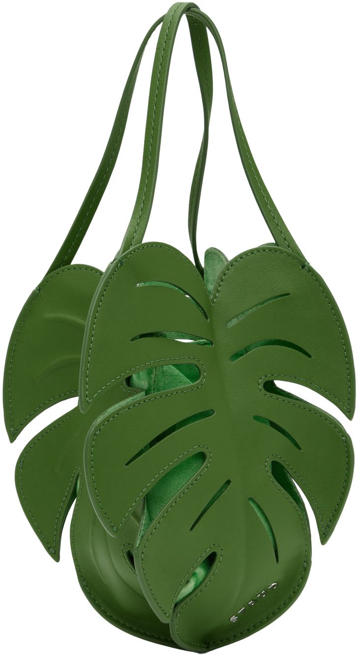 Sculptural grained leather shoulder bag in green. · Cutouts throughout · Twin fixed carry handles · Logo hardware at side · Embossed detailing at back face · Magnetic closure · Detachable suede pouch at interior · H8.5 x W5.75 x D3 Supplier color: Leaf Luxury Green Top Handle Bucket Bag, Luxury Green Tote Bucket Bag, Luxury Green Bucket Bag For Daily Use, Luxury Green Tote Bag, Green Top Handle Bag With Detachable Handle, Green Tote Bag With Detachable Handle, Staud Bags With Removable Pouch, Green Top Handle Bag, Staud Rectangular Bag With Removable Pouch