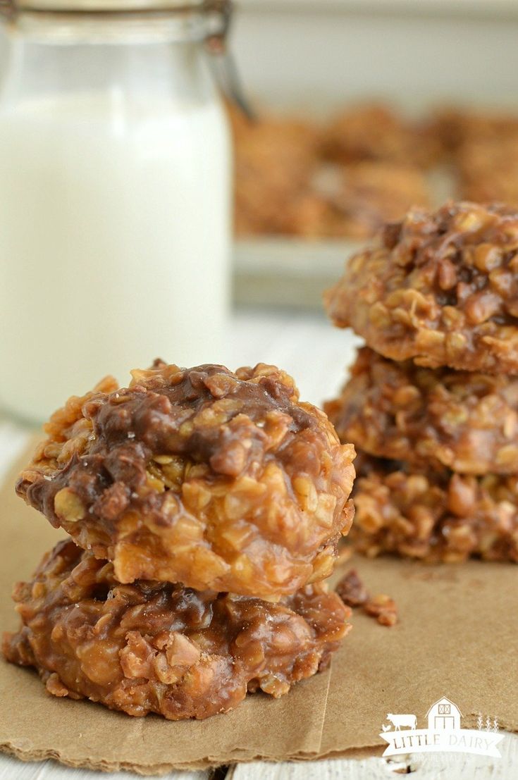 three oatmeal cookies stacked on top of each other next to a glass of milk