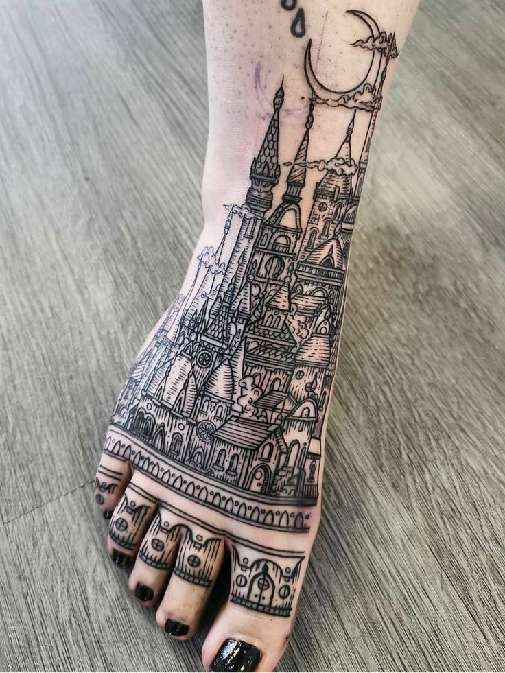 a woman's foot with a castle tattoo on it