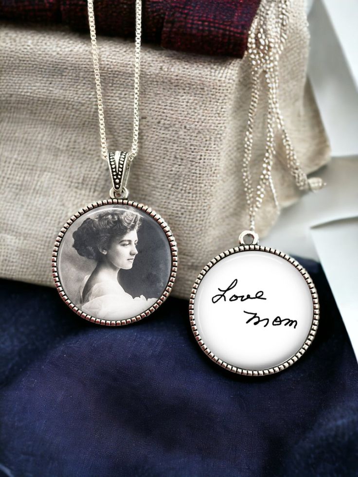 two necklaces with an image of a woman in the middle one has a name on it