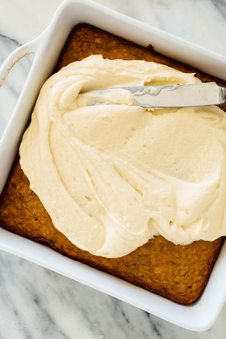 a cake in a pan with frosting and a spatula on the top is ready to be eaten