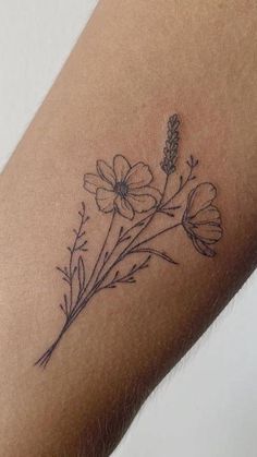 a small tattoo on the arm of a woman's arm with flowers and leaves