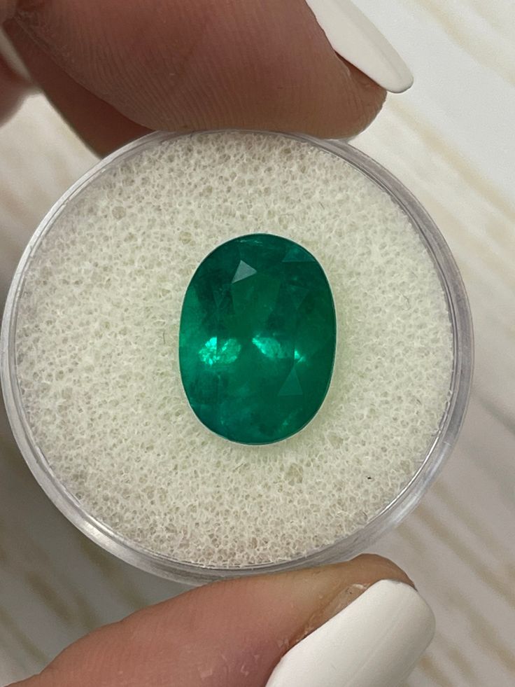 a close up of a person holding a green gems