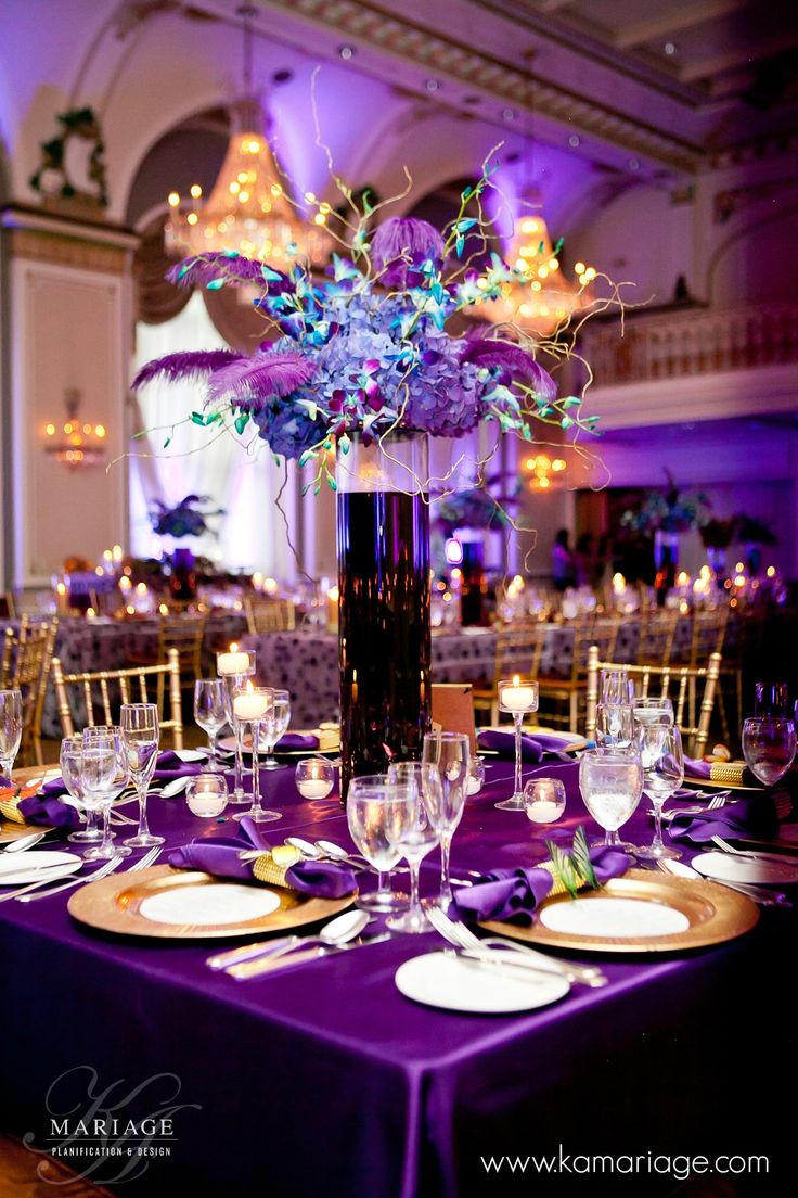 the centerpieces on this table are purple and gold, while the rest of the tables are white