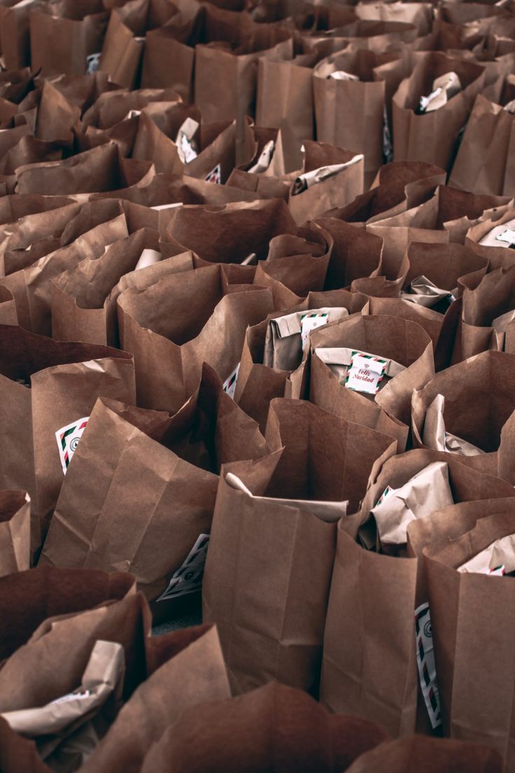 many brown paper bags are stacked on top of each other