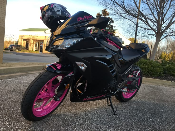 a black and pink motorcycle parked on the street