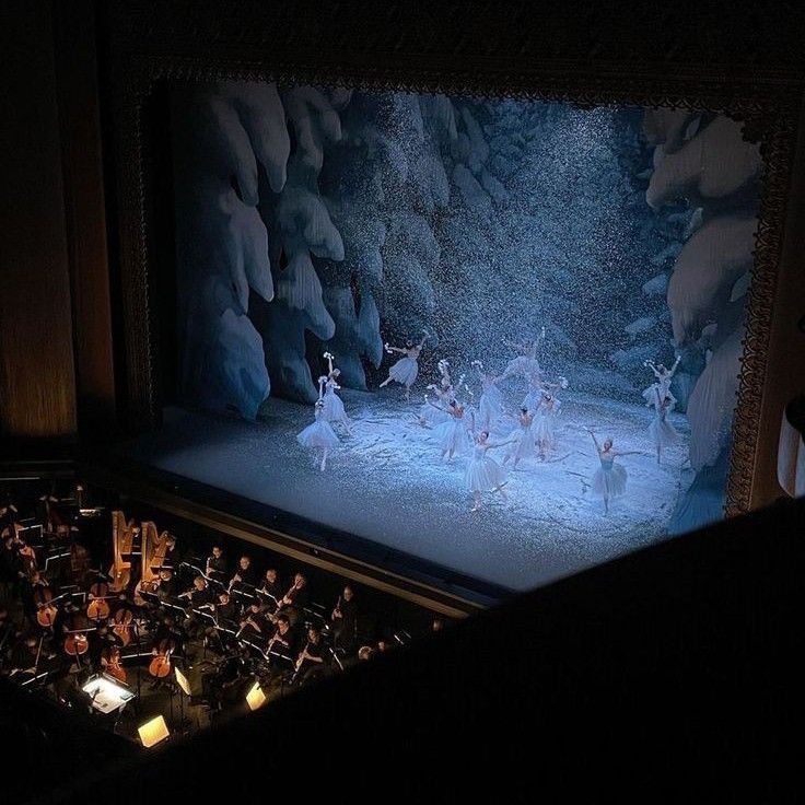 a group of ballet dancers on stage in front of a large screen with music notes