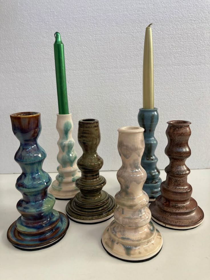 there are many different colored vases with one candle in the middle and one on the other